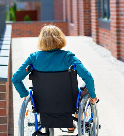 Persona con discapacidad utilizando una rampa para entrar a un centro de rehabilitación