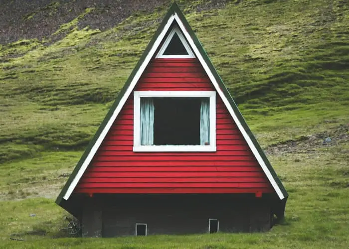 Casa minimalista pequeña y triangular construida sobre las faldas de una montaña