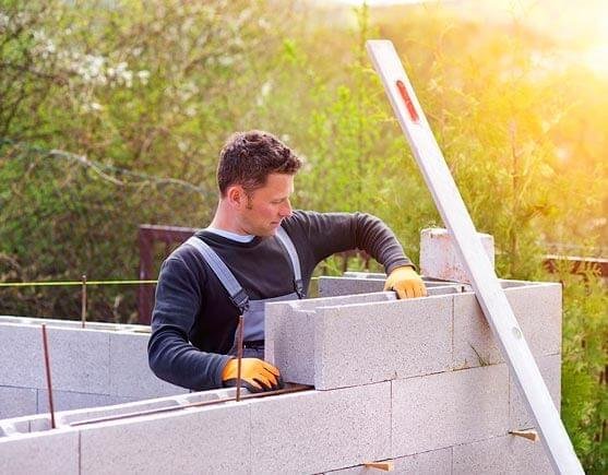 Trabajador de la construcción conolocando blocks en muro Trabajador de la construcción conolocando blocks en muro