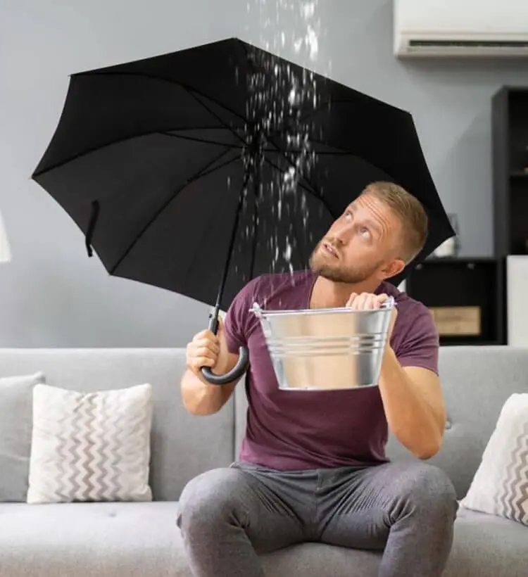 Hombre cubriendose de filtraciones de agua en techo