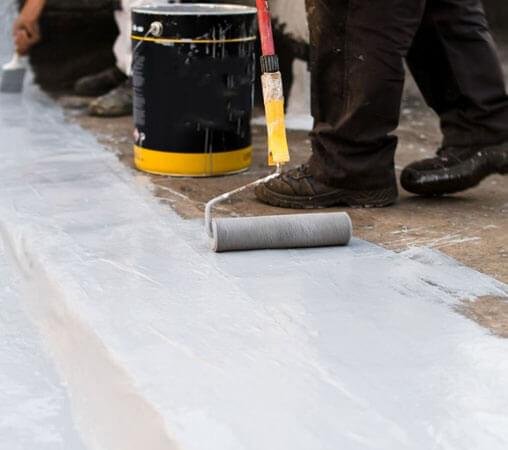 Trabajador aplicando impermeabilizante para evitar filtraciones de agua Trabajador aplicando impermeabilizante para evitar filtraciones de agua