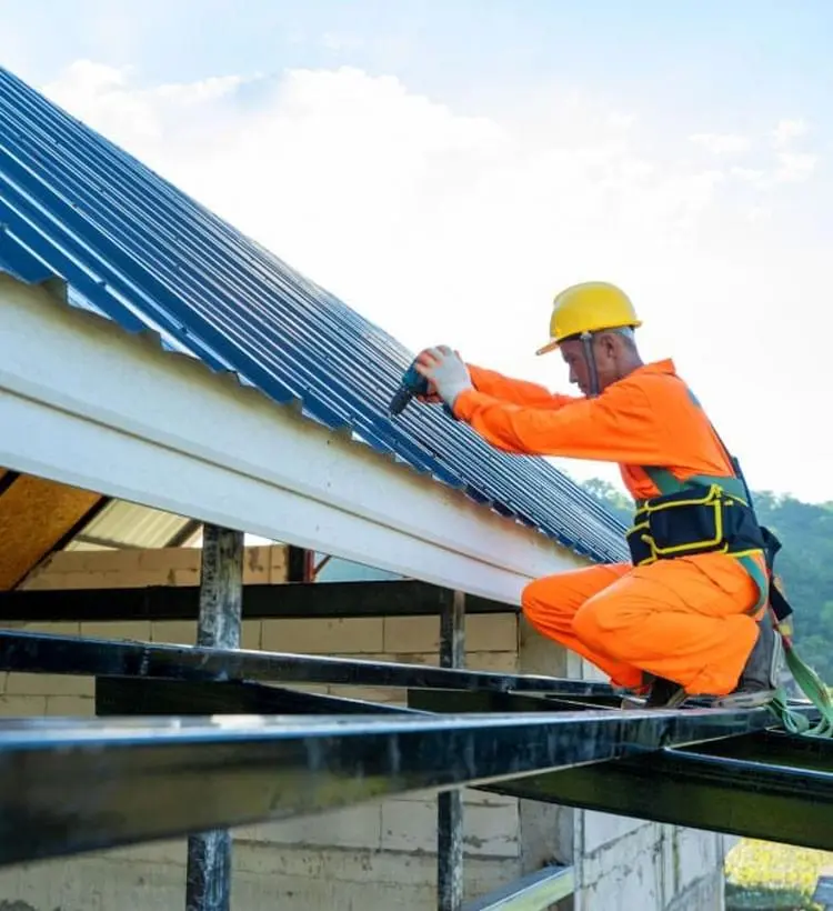 Trabajador de la construcción instalando un techo de lámina en una casa