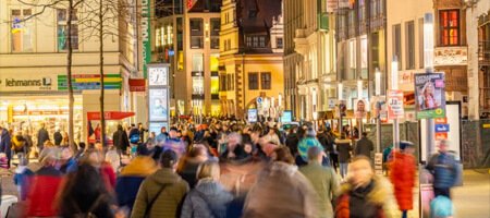 Vista a una calle con distintas tiendas llena de personas Vista a una calle con distintas tiendas llena de personas