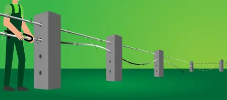 Persona realizando la instalación de las hileras de alambre de púas a través de los postes de concreto - Cercar con alambre de púas