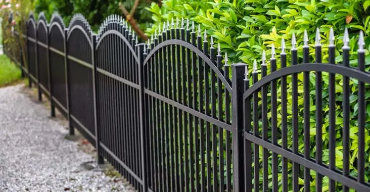Cerca de estacas blancas de altura baja instalada para proteger los jardines de una casa Cerca de estacas blancas de altura baja instalada para proteger los jardines de una casa