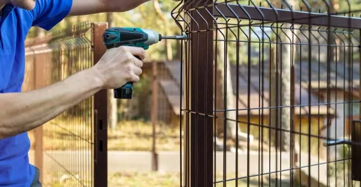Cercas perimetrales de reja de acero siendo instaladas para incrementar la seguridad de una casa Cercas perimetrales de reja de acero siendo instaladas para incrementar la seguridad de una casa