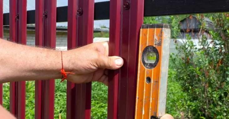 Trabajadores instalando vallas abiertas sin impedir la vista al interior del terreno de una casa Trabajadores instalando vallas abiertas sin impedir la vista al interior del terreno de una casa