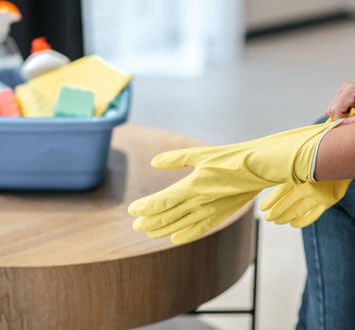 Acercamiento al brazo de una mujer limpiando una mesa de centro de herrería Acercamiento al brazo de una mujer limpiando una mesa de centro de herrería
