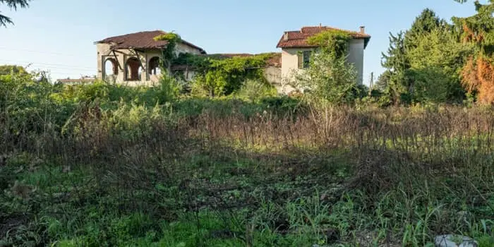 Casa abandonada con signos de deterioro en medio de una zona boscosa Casa abandonada con signos de deterioro en medio de una zona boscosa