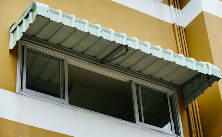 Marquesina de aluminio sobre la ventana del segundo piso de una casa Marquesina de aluminio sobre la ventana del segundo piso de una casa
