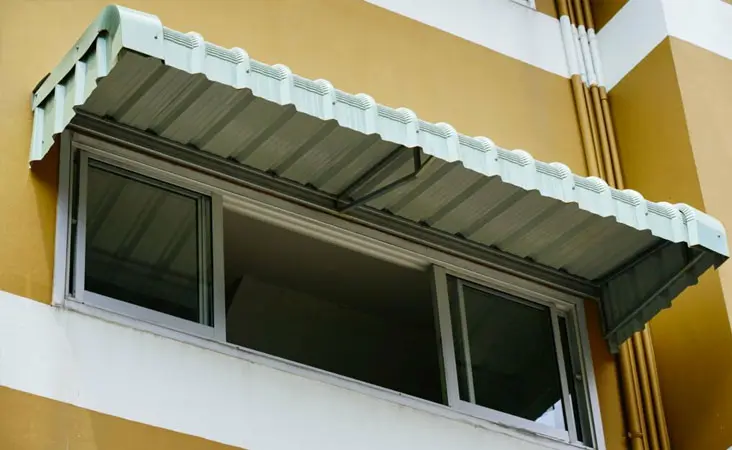 Marquesina de aluminio sobre la ventana del segundo piso de una casa Marquesina de aluminio sobre la ventana del segundo piso de una casa