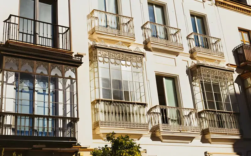 Frente de un edificio con ventanas de herrería elegantes en toda su fachada