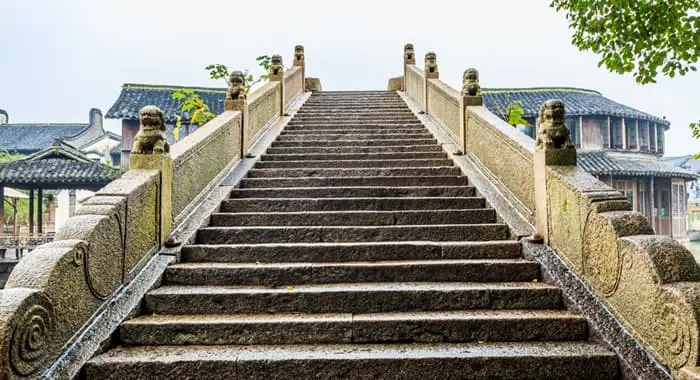 Escalinata antigua con barandales de piedra labrada con esculturas de leones y otros elementos decorativos
