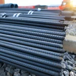 Grupos de varillas de acero corrugado atados colocados en medio de una obra en construcción