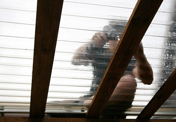 Trabajador instalando lámina de policarbonato acanalado en un bastidor de madera