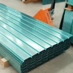 Pila de láminas tipo tablero verde galvanizadas, puestas en un patín industrial.