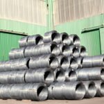 Rollos de alambre galvanizado apilados afuera de una bodega