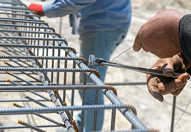 Trabajadores asegurando estribos de alambrón con alambre recocido