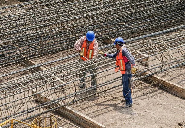 Trabajadores elaborando la estructura de una columna con varilla corrugada
