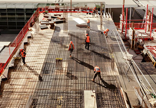Trabajadores instalando malla electrosoldada sobre edificio