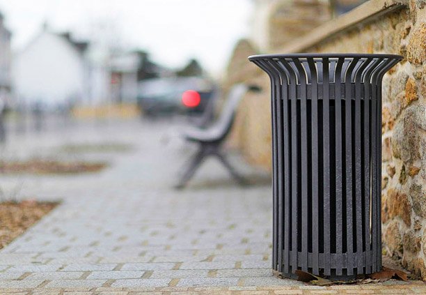 Bote de basura elaborado con solera de acero colocado en un parque público