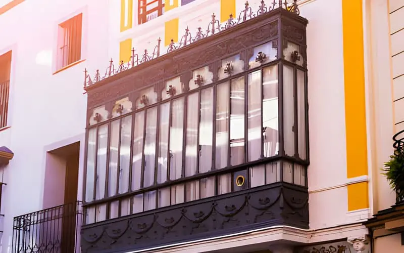 Frente de un edificio clásico con una ventana de herrería elegante
