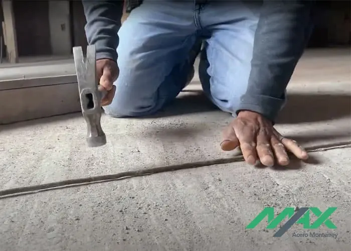 Albañil enderezando un tramo de alambrón para después fabricar un estribo