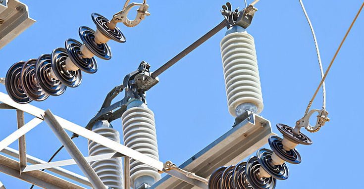 Subestación eléctrica con líneas de potencia y materiales aislantes de electricidad.