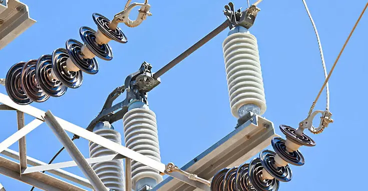 Subestación eléctrica con líneas de potencia y materiales aislantes de electricidad.