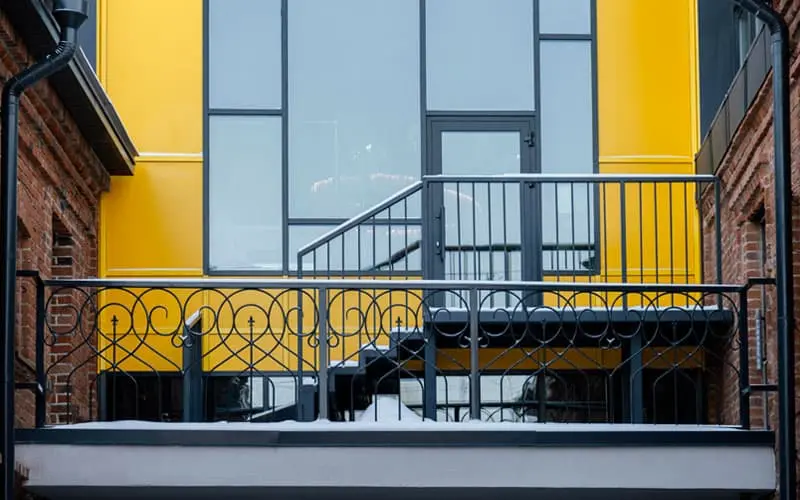 Ventanas de herrería modernas en un edificio color amarillo
